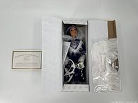 Porcelain doll in original box with certificate of authenticity.