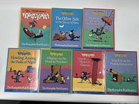 Seven comic books laid out side by side, showing full covers with colorful illustrations and titles