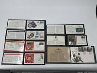 Lot of 7 commemorative coins with certificates and special covers shown arranged on a surface.