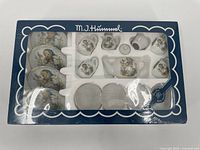 Full view of MJ Hummel porcelain tea set in original box with clear window and blue scalloped design