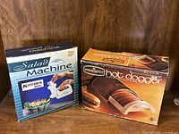 Both boxed items side by side on wooden surface showing product names and packaging condition.