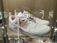Pair of Nike Flyknit basketball shoes side view on glass shelf