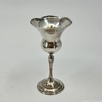 Full view of silver chalice showing tulip-shaped cup, tapered stem, and stepped round base.