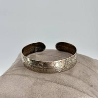 Front angle view of sterling silver cuff bracelet showing stamped floral pattern