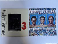 Photo showing both vinyl record album covers side by side on a white surface.