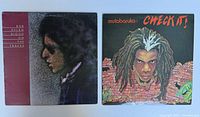 Photo of both vinyl record albums showing their front covers, Bob Dylan on left, Mutabaruka on right.