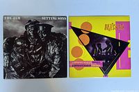 Two vinyl record albums side by side: The Jam "Setting Sons" and The Buzzcocks "A Different Kind of Tension" with visible cover art.