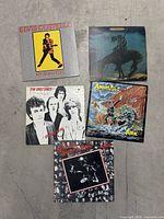 Five vintage vinyl record albums arranged on floor: Elvis Costello - My Aim Is True, Bob Dylan - Self Portrait, The Only Ones - Special View, The Animals - Ark, and The Clash self titled album.
