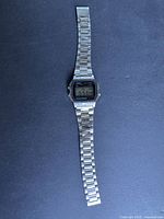 Full front view of Casio digital watch showing stainless steel band and digital display.