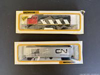 Two Bachmann HO scale train cars in original boxes, a red and black locomotive (model 916) and a white Canadian National refrigeration boxcar.