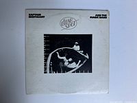 Front cover of the album showing title and band with artwork.