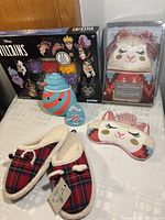 Photo showing Disney Villains Perler bead kit, llama hot water bottle cover in packaging, llama sleep eye mask, and red plaid slippers.