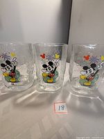 Front view of the three glasses showing colorful Mickey Mouse with fireworks designs.