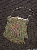 Antique floral mesh purse with metal frame and clasp, showing missing bits at the bottom edge.