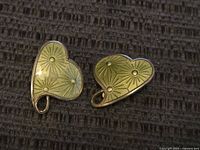 Front view of the heart-shaped earrings showing yellow enamel with raised starburst design.