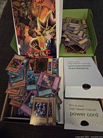 Large collection of Yu-Gi-Oh! cards in a green and white box, various cards displayed, some showing their artwork and names such as 'Spirit Reaper'.