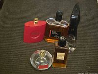 Five vintage perfume and cologne bottles on a textured brown surface.