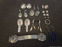 Group shot of 11 jewelry pieces on a dark textured surface