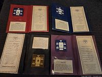 Four gemstones each mounted and accompanied by a certificate inside folders.