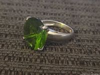 Close-up front view showing the large faceted green stone set in sterling silver band.