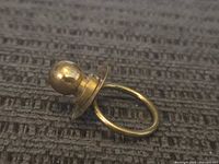 Side view of sterling silver pacifier ring showing the rounded bulb and ring band.