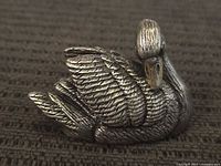 Close front-side view of the detailed sterling silver swan figure showing feathers and head shape