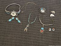 Group shot of all jewelry pieces on dark fabric
