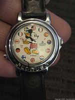 Close up of the watch face showing Mickey Mouse with international flags as hour markers and Lorus branding.