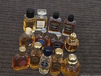 Entire lot of vintage miniature sample perfumes arranged on carpet, showing various brands and bottle shapes.