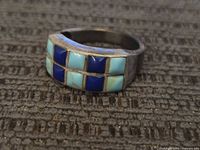 Front view of vintage sterling silver ring with turquoise and lapis stone inlay.