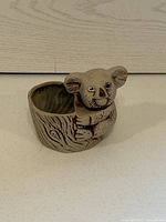 Photo of small koala bear ceramic planter from the front showing the hollow planter area and detailed koala face and tree trunk texture.