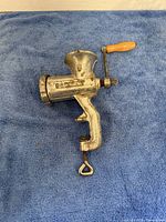 Top and side views of the metal Porkert meat grinder showing the wooden handle, clamp base, and embossed branding.