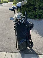 Photo showing the full golf bag loaded with various Top Flite Intimidator golf clubs placed outdoors on pavement.
