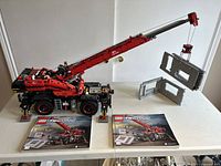 Assembled LEGO Technic crane 42082 on table with two instruction manuals