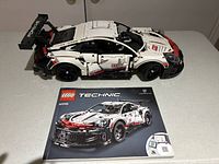 Assembled white Lego Porsche 911 RSR model alongside the instruction manual