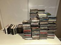 Multiple stacks of CD jewel cases on a table