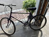 Side view of a purple Miele mountain bike showing the full frame, wheels, seat, pedals, and handlebars.