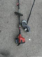 Overview of Toro gas lawn trimmer with red engine housing and Ryobi garden edger attachment