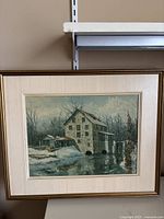 Front view of the framed embossed painting showing a mill scene with winter landscape and water reflection.
