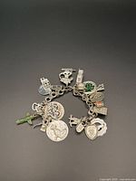 Full view of the sterling silver charm bracelet with all charms displayed around the chain.