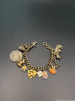 Full view of curb link bracelet with all attached charms laid flat on dark background