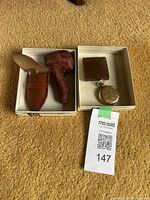 Vintage carved sailor Meerschaum pipe with amber stem and leather pouch inside small box, next to gold-tone pocket watch in separate box.