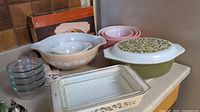 Overview of all items in the lot including the casserole, bakeware, mixing bowls, and small glass bowls arranged on a countertop.