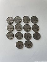 14 Buffalo nickels arranged in a triangular block, showing the reverse side with bison design.