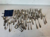 Full assortment of flatware and fabric case arranged on surface