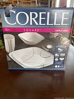 Corelle 16-piece Square Simple Lines dish set in unopened retail box showing product image and listing of contents.