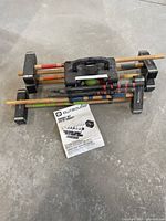 Croquet set including mallets placed horizontally on a stand, instruction manual and croquet balls visible