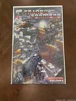 Full view of the Transformers comic book in protective sleeve showing cover art and multiple signatures.
