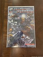 Full front cover of the Transformers comic book in protective sleeve with visible signatures and cover art.
