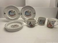 All items displayed together showing plates, bowl, two-handle mug, one-handle mug, and Bobtails bunny teacup overall condition